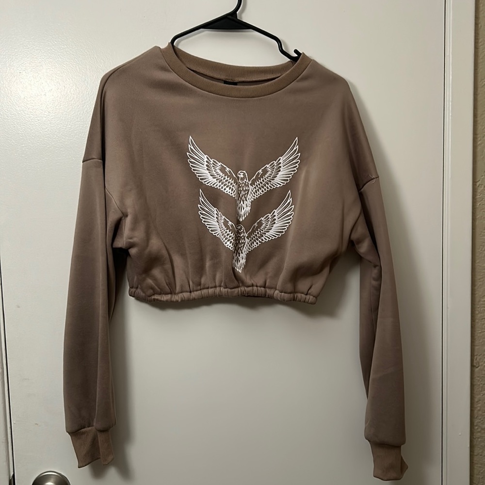 Tan cropped long sleeve sweatshirt with white eagle design